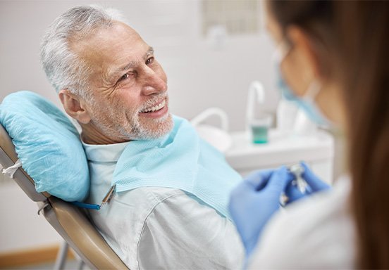 Smiling patient speaking to dental team member