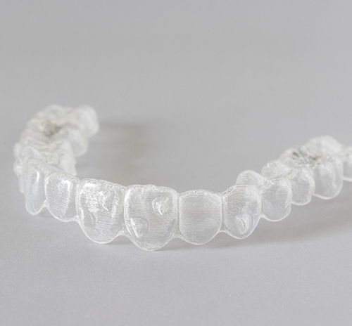 Clear aligner lying on gray surface