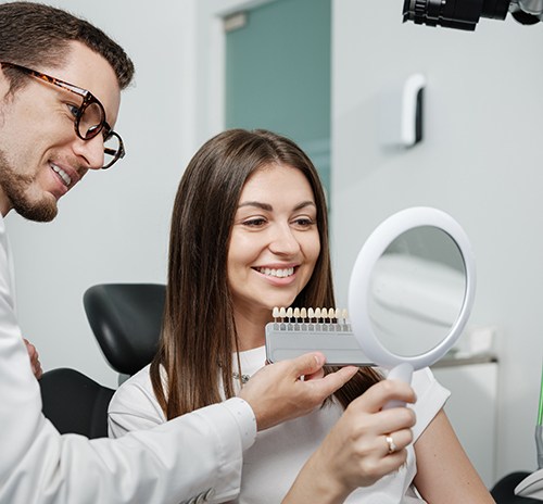 Dentist using shade guide to prepare for veneers